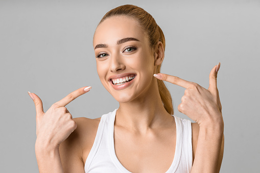 Lächelnde Frau nach einer gründlichen Zahnreinigung